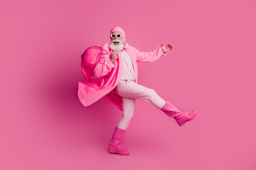 Full body portrait of charismatic grandfather wear coat boots carry xmas bag walk isolated on pink color background