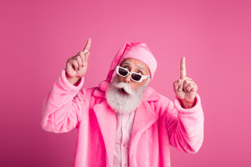 Portrait of funky impressed elderly man look indicate fingers up empty space christmas offer...