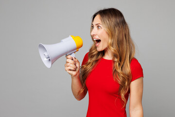 Young excited fun happy woman she wear red t-shirt casual clothes hold in hand megaphone scream...