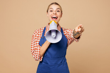 Young woman barista bartender barman employee wears blue apron red shirt work in coffee shop scream in megaphone announces discounts sale Hurry up isolated on plain beige background. Business concept.