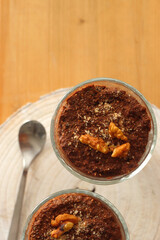 Two bowls of chia seed, chocolate and orange pudding. Healthy snack, wooden background. Top view.