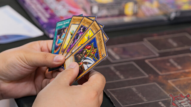 Budokan Geek Convention In GUAYAQUIL, ECUADOR - 
OCT 13, 2024 - Hands holding Yu-Gi-Oh! trading cards during a duel. The image captures the intensity of the strategic card game based