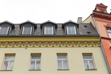 The structure is a building that features a roof equipped with several windows situated on its surface, enhancing its overall aesthetic appeal