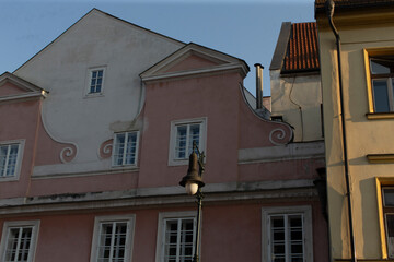 There is a row of several buildings with a distinctive pink building situated right in the middle, creating an interesting visual contrast