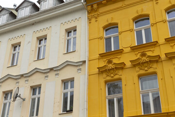 A vibrant yellow building stands proudly adjacent to a pristine white building, creating a striking contrast in their facades and colors