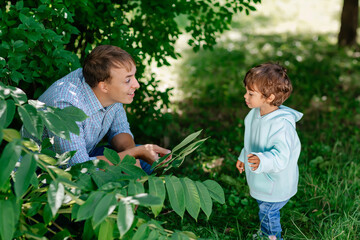 Dad playing with his cute child in the park. Father and son having fun outdoors