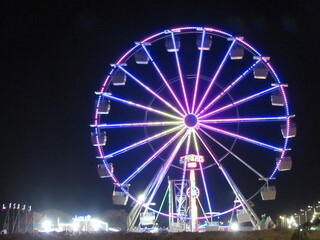 Ferris wheel all lit up in an amusement park forming a mosaic of lights