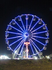 Ferris wheel all lit up in an amusement park forming a mosaic of lights