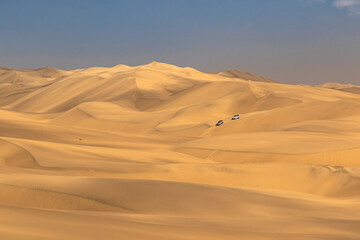 Sandwich Harbour in Namibia mit einem 4x4 Fahrzeug - eine Landschaft zwischen Dünen, Wüste und dem Atlantik