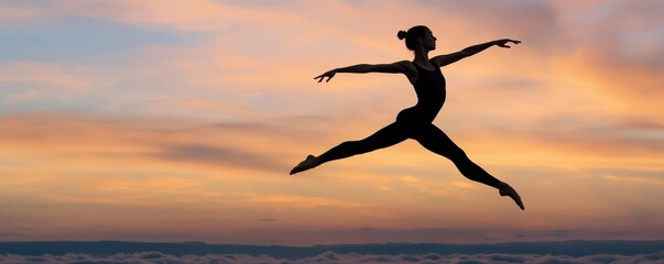 Silhouette of a ballerina performing a graceful leap against a vibrant sunset sky