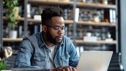 Young man working on laptop in a modern office space during the day