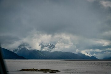 Mountain range with cloudy sky over calm water