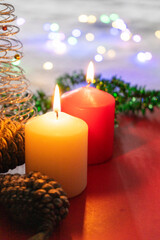 Christmas still life with burning candles and christmas decorations on red background