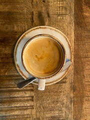 Top-down view of a cup of coffee on a rustic wooden table