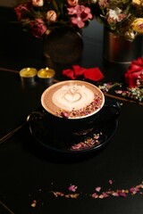 Artistic coffee cup with latte art and flower petals.
