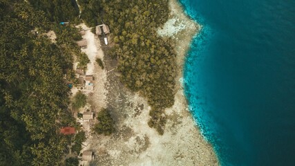 Aerial view of tropical coastline with lush greenery and turquoise waters.
