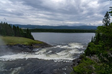 Scenic view of a river flowing through a green landscape in Taennforsen, Sweden on a cloudy day