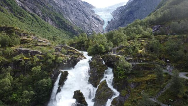 Drone view of Kleiva Fossen waterfall on green-covered mountain at the daytime in Briksdal, Norway