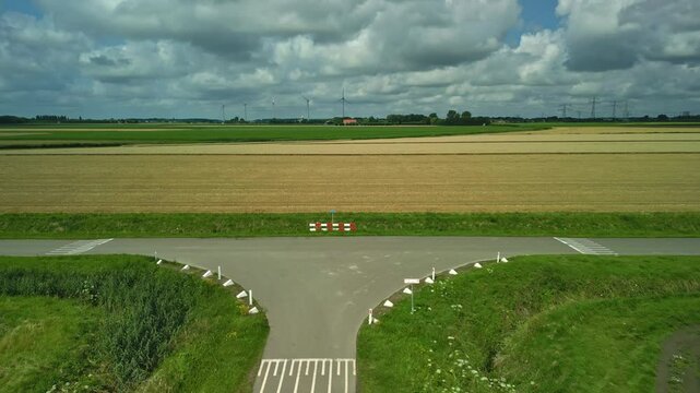 Drone view of a T junction in a road in the middle of the Dutch polder on a cloudy day
