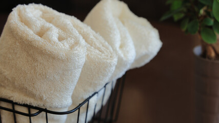 White and beige soft natural cotton towels in a basket for body care