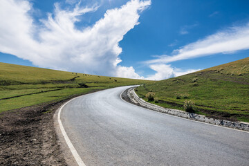 Countryside asphalt road and green grassland pasture nature landscape under blue sky. road trip.