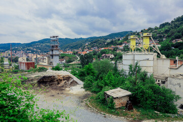Industrial area showcasing construction activity in Kosovo's tranquil landscape amidst green hills and small towns