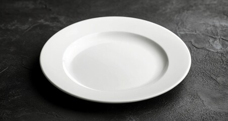 Simple white plate on a dark background showcasing minimalist design and elegance in dining