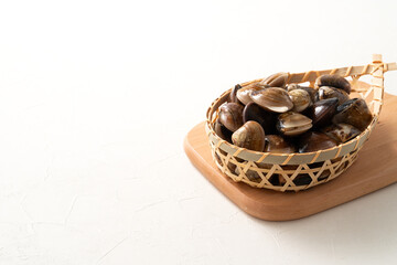 Raw fresh clams seafood in a sieve on white table background.
