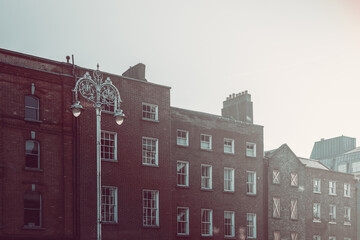 A vintage style photo of Georgian buildings in Dublin, featuring classic red-brick facades bathed...