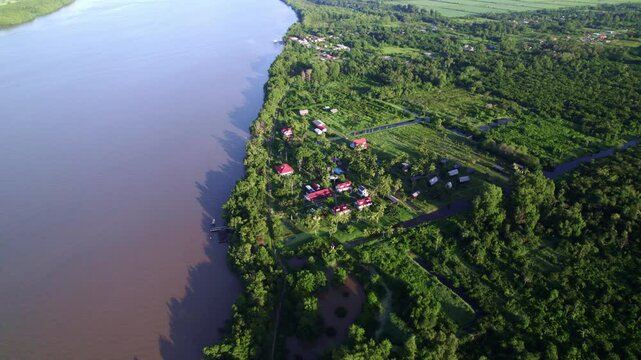 Drone flyover Frederiksdorp over Commewijne river, Suriname rainforest, birds eye view