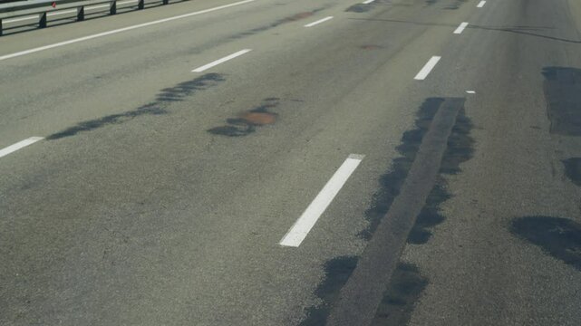 Bad road, patched asphalt, view from the car. High quality 4k footage