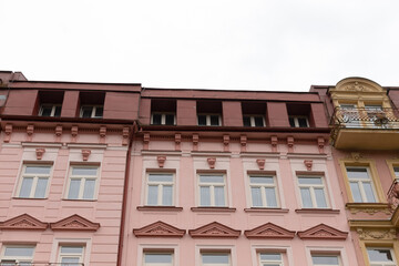 Obraz premium There is a charming pink building featuring a lovely balcony positioned at the very top, enhancing its overall attractiveness and appeal
