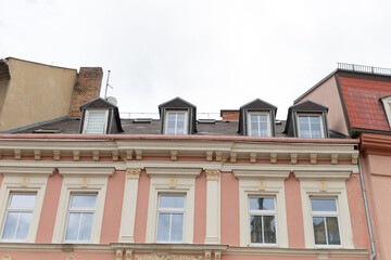 Obraz premium A tall and expansive building that features a large number of windows and has a noticeable chimney situated on the roof area