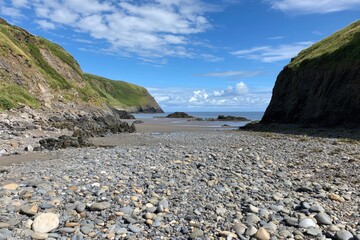 Exploring the tranquil rocky beach nestled between lush green cliffs on a sunny day