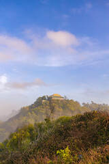 Fototapeta premium Breathtaking panoramic view of a hidden paradise, with rolling hills and a misty mountaintop.