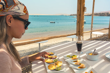 A woman is sitting at a table with a plate of food in front of her