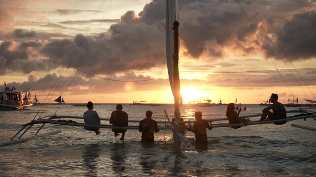 Sunset sailing with a traditional paraw boat in the turquoise waters of Boracay Island, Philippines