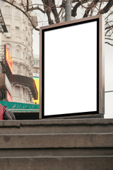 Vertical light box mock up at top of stairs leading down to underground subway train station. Urban city street scene. Out of home OOH advertisement blank template. Low angle, looking up view.