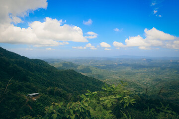 Naklejka premium Breathtaking view of lush green hills and blue skies over Kota Kinabalu during a sunny day