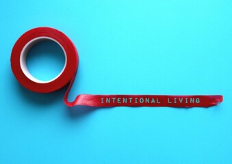 Red tape on blue background with words INTENTIONAL LIVING, means understanding fundamental beliefs and values and making decision to live everyday for those values actively
