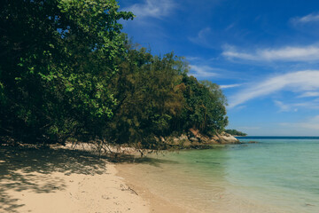 Fototapeta premium Relaxing beach view at Mamutik Island in Malaysia showcasing turquoise waters and lush greenery under a clear blue sky