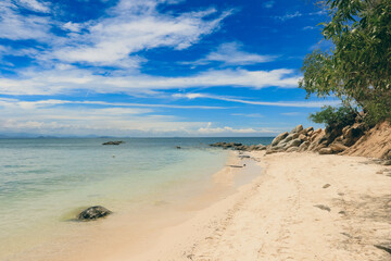 Relaxing beach view with gentle waves at Mamutik Island, Malaysia under a clear blue sky