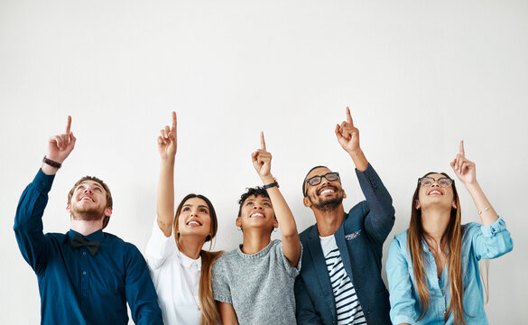 Business people, smile and group pointing up for mockup, wall and white background space. Creative employees, teamwork and diversity with hand gesture, collaboration and decision for choice approval