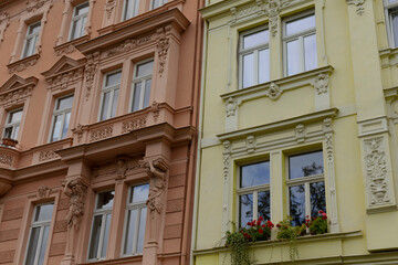 Obraz premium Two charming buildings, adorned with vibrant flowers in their windows, stand elegantly next to each other in this lovely neighborhood