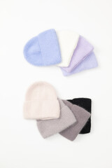 Collection of stylish knitted hats (pink, beige, black, white, gray, red) Composition of lined hats. A set of autumn - winter hat accessories