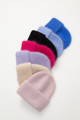 Collection of stylish knitted hats (pink, beige, black, white, gray, red) Composition of lined hats. A set of autumn - winter hat accessories