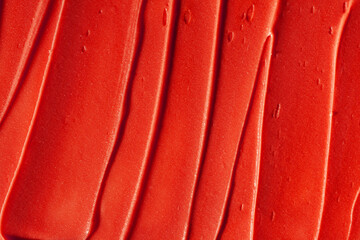 Lipstick saturated neon red smudge background texture satin finish