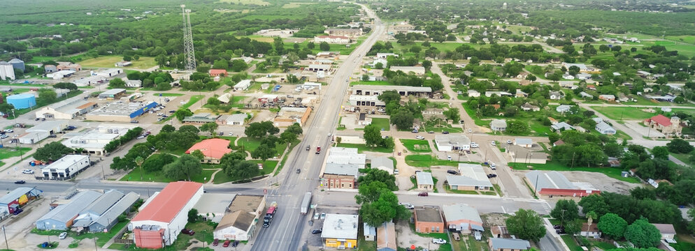 Panorama aerial view small town Three Rivers South of San Antonio along U.S. Highway 281, Texas, mix of industrial, business buildings and residential houses farmland, suburban rural, lush green