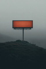 Empty billboard stands alone on a foggy hilltop during early morning light in a desolate landscape