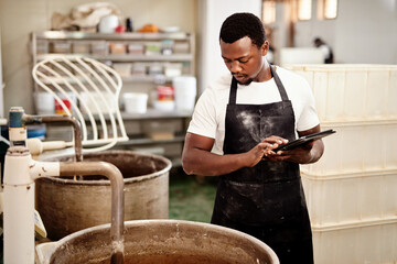 Tablet, black man and baker with dough mixer for food safety, cooking or health compliance check. Technology, bakery and factory for manufacturing, production startup or quality inspection of machine